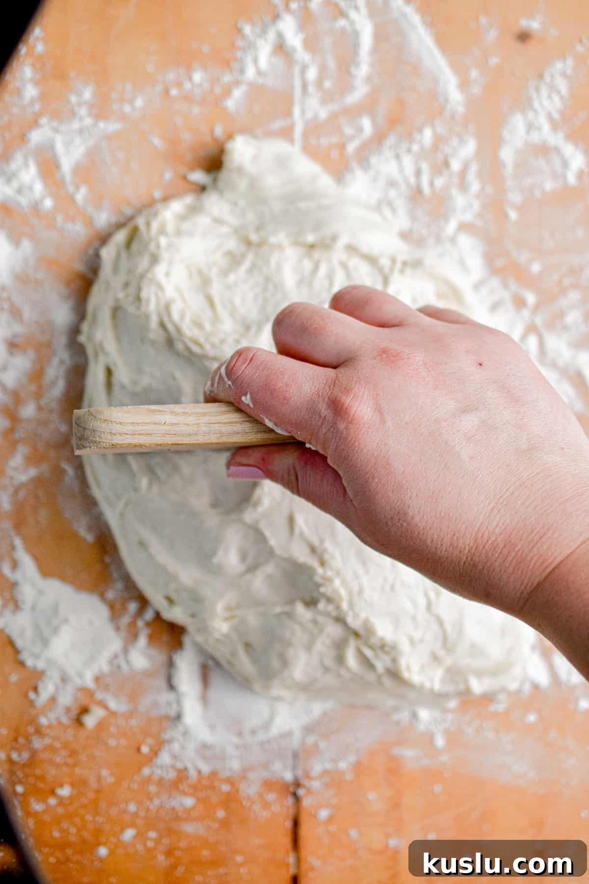 Sourdough Cast-Iron Pizza Without Yeast: Crispy Homemade Pie 6 The dough is placed on a floured surface and cut in half to make two balls.