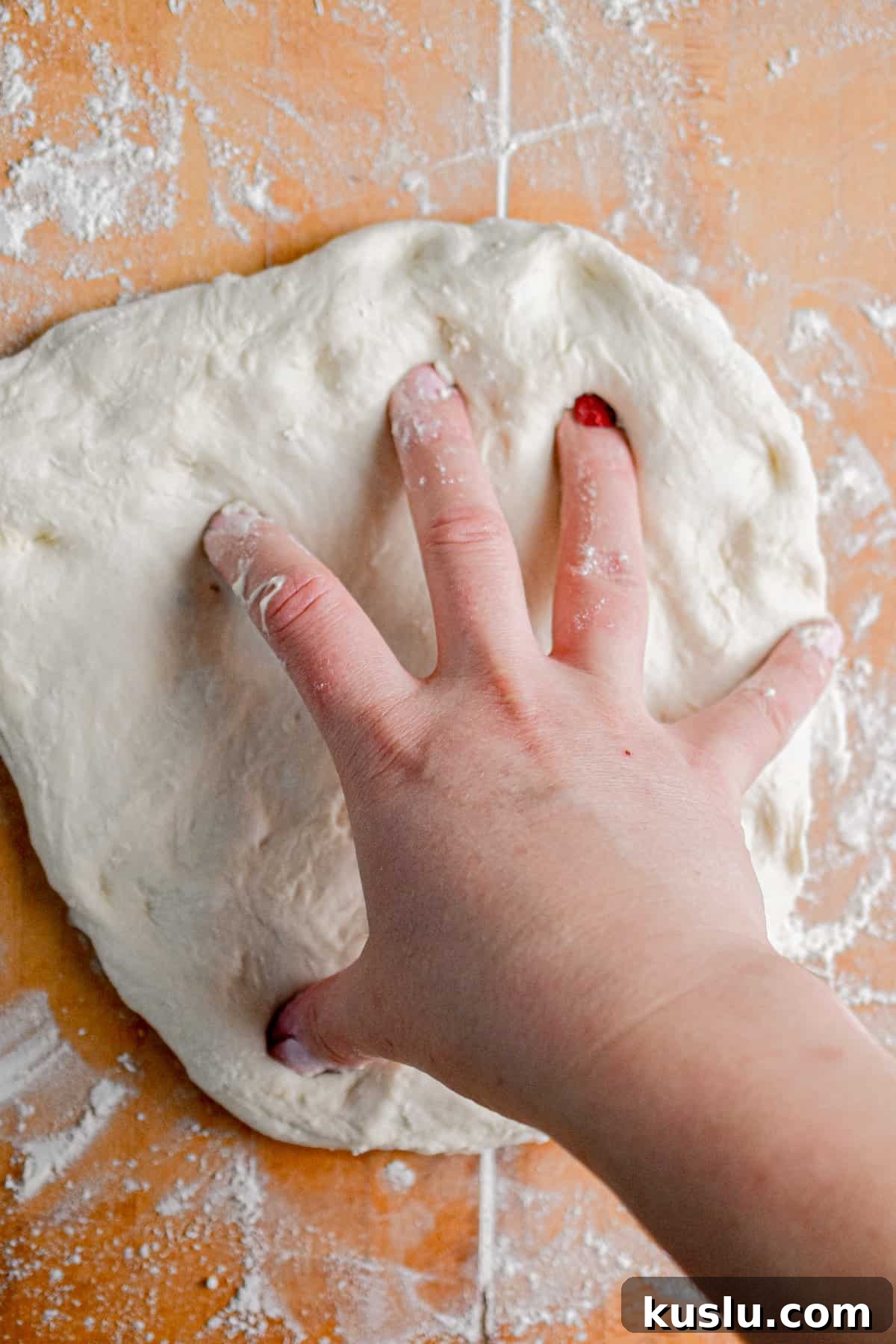 Sourdough Cast-Iron Pizza Without Yeast: Crispy Homemade Pie 7 The dough is shaped into flat pizza crusts with a hand.