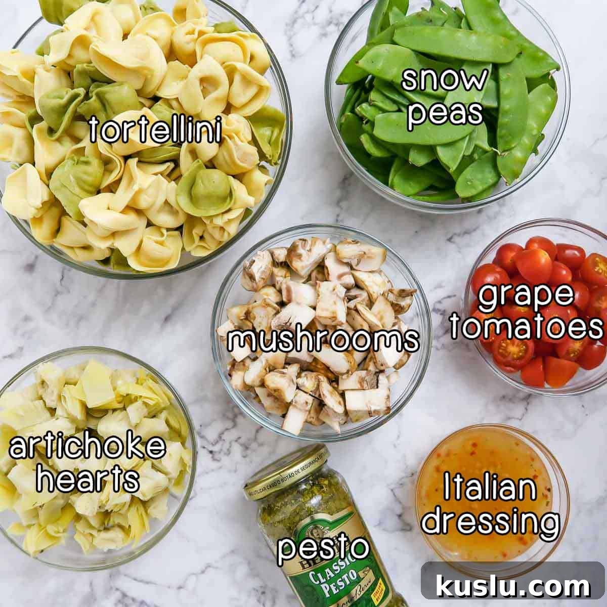 Pesto Tortellini with Artichokes and Snow Peas Recipe 3 Overhead shot of ingredients- tortellini, snow peas, mushrooms, grape tomatoes, artichoke hearts, pesto, and Italian dressing.