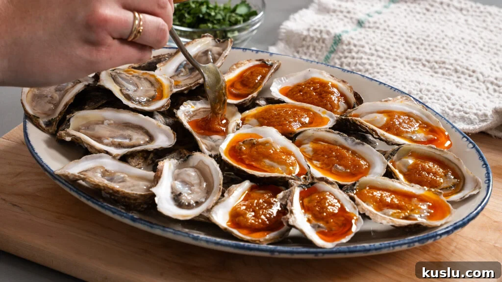 Spooning hot butter mixture over oysters for a delicious butter poached oyster recipe.