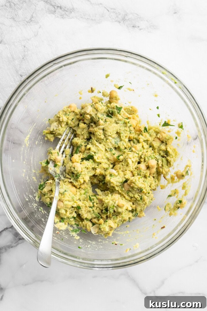 Smashed chickpea avocado salad in bowl with fork