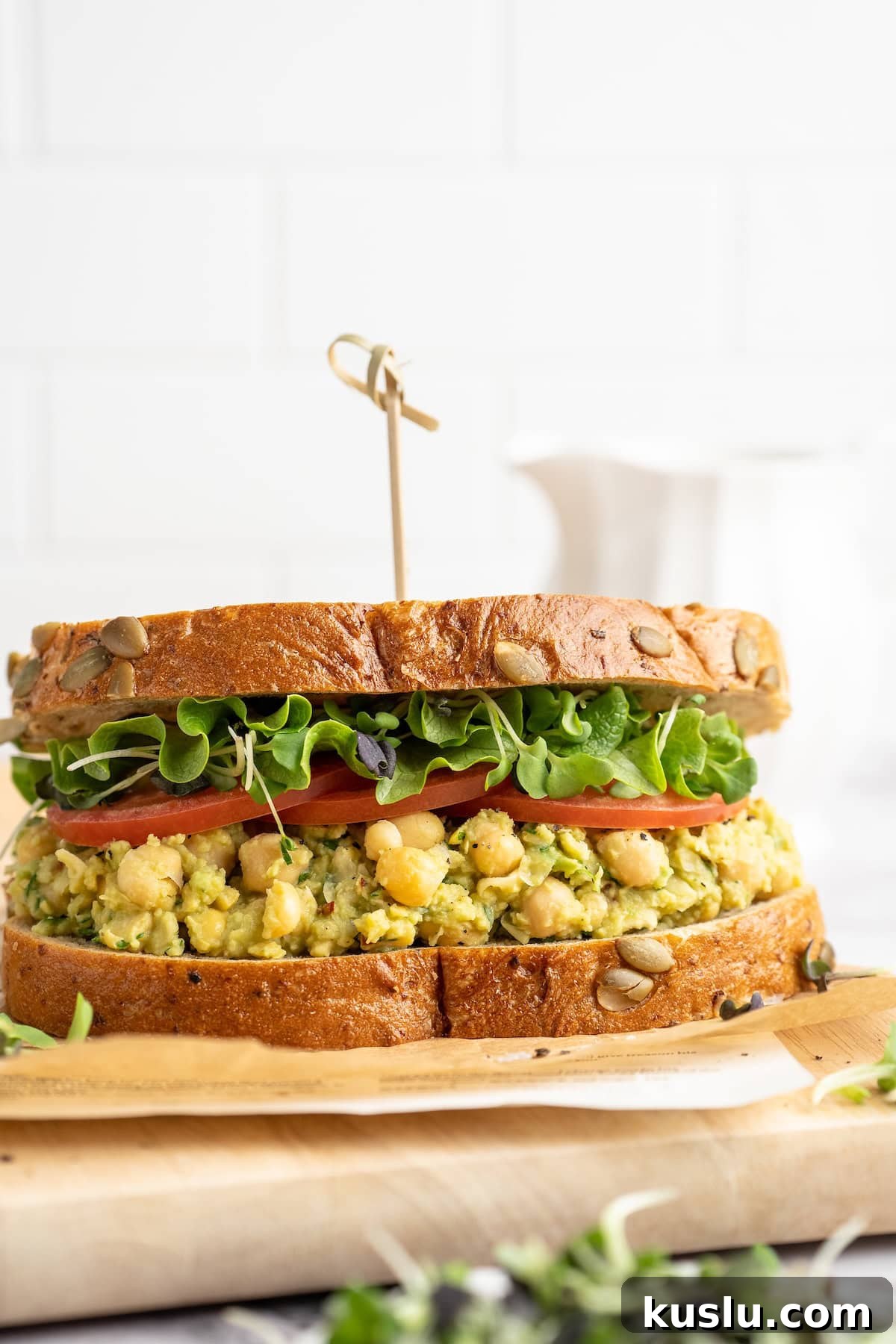 Smashed chickpea avocado sandwich on cutting board
