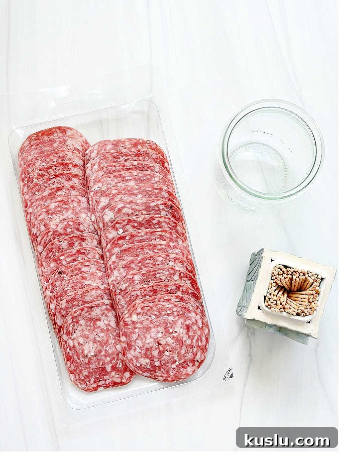 ingredients for making a salami rose - salami, glass, toothpicks