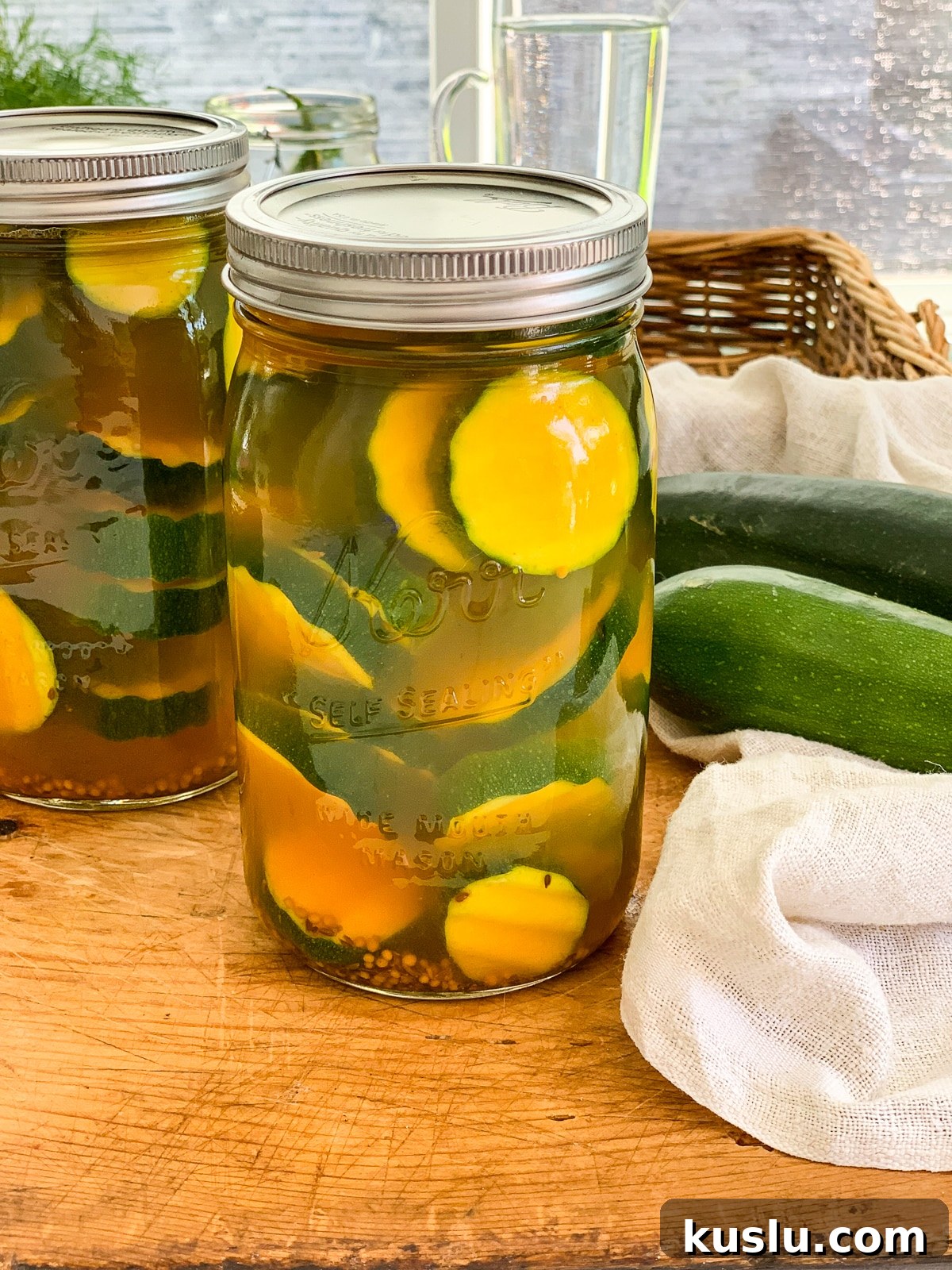 Quick Refrigerator Zucchini Pickles — No Canning Needed 2 Two jars of zucchini pickles on a kitchen cutting board