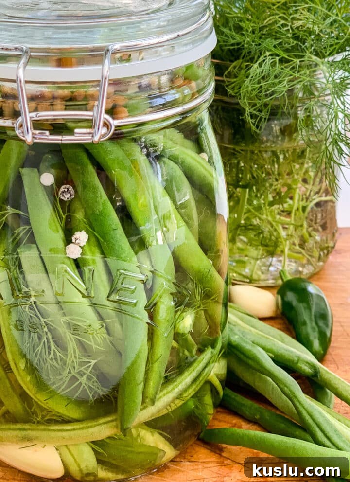 A clear glass jar filled with pickled green beans