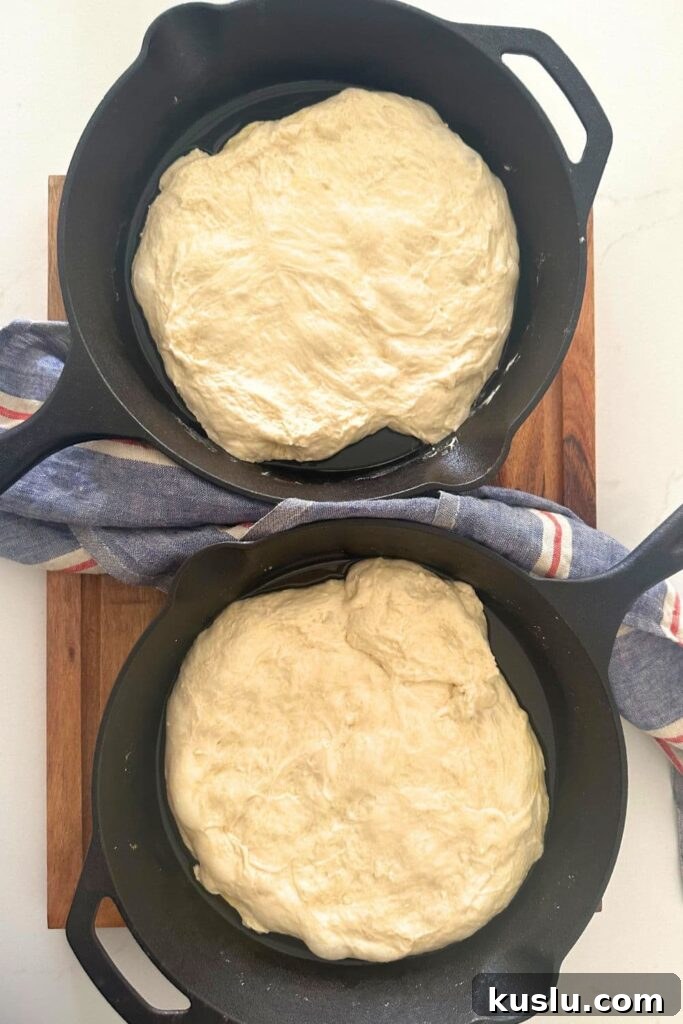 Two skillets filled with focaccia dough