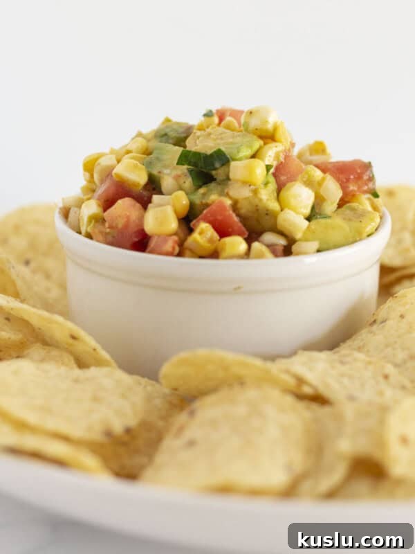 Pepperoni Pizza Football Cheese Ball Recipe: Game Day Appetizer 9 Corn and avocado salsa served in a white bowl with corn chips.