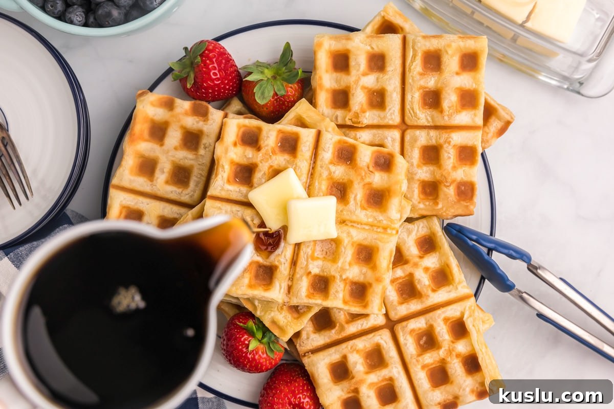 Waffles topped with butter and maple syrup.
