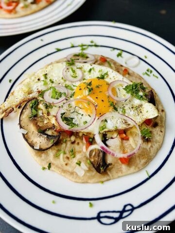 Egg on tortilla ready to be served and sprinkled with fresh herbs and some red onion rings.