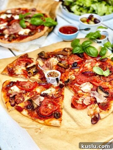 Homemade pizza on brown parchment paper without a slice