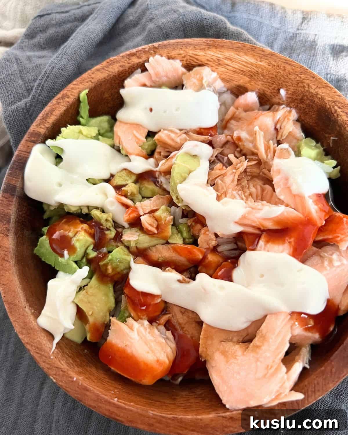 Finished salmon bowl with mayo, hot sauce, and soy sauce. 