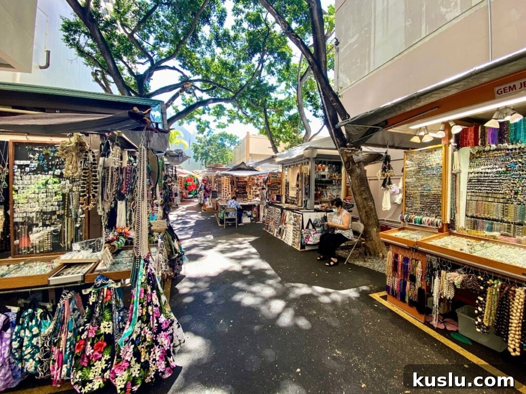 Open-air stalls at Duke’s Marketplace in Waikīkī, Hawaiʻi, offering handcrafted jewelry, Hawaiian souvenirs, and local gifts in a vibrant alleyway.