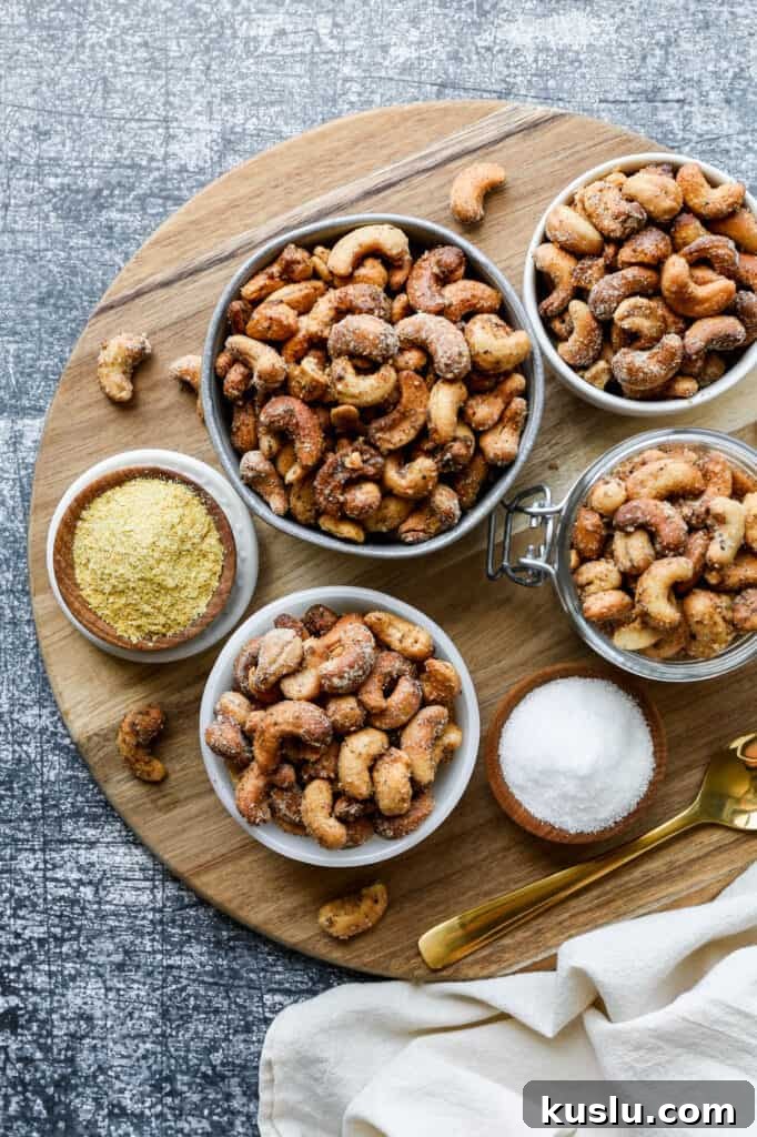 Crispy Salt and Pepper Cashews Made in an Air Fryer 2 small bowls of air fryer salt and pepper roasted cashews on a round wooden cutting board