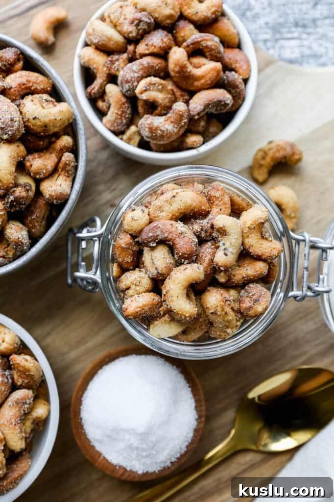 Crispy Salt and Pepper Cashews Made in an Air Fryer 3 small bowls of air fryer salt and pepper roasted cashews on a round wooden cutting board