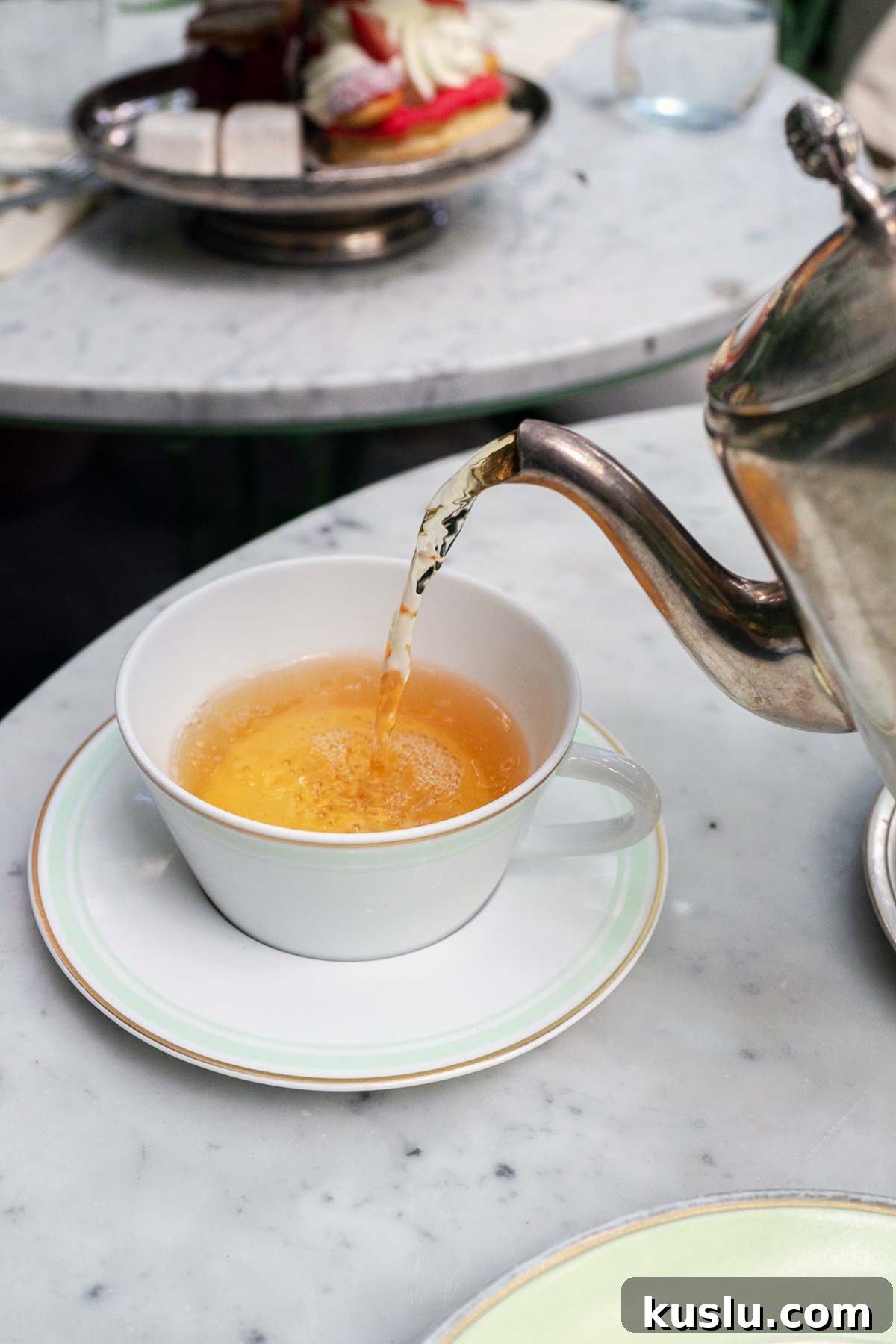 Pouring tea into a cup at Laduree Soho.
