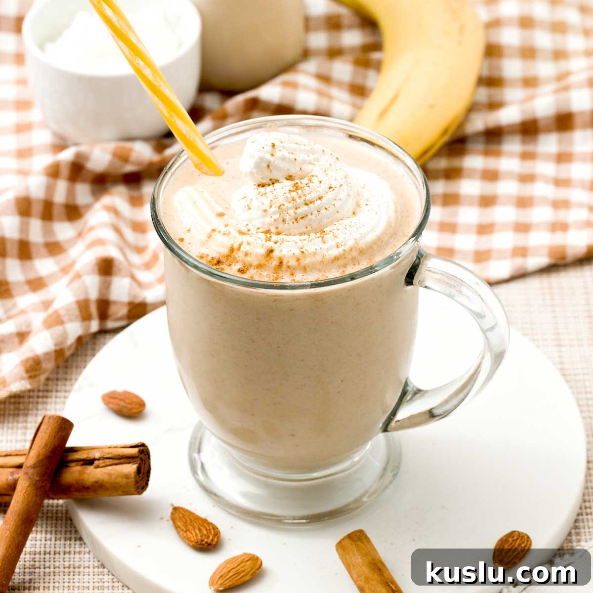 A cinnamon roll protein smoothie with greek yogurt and whipped cream on top.