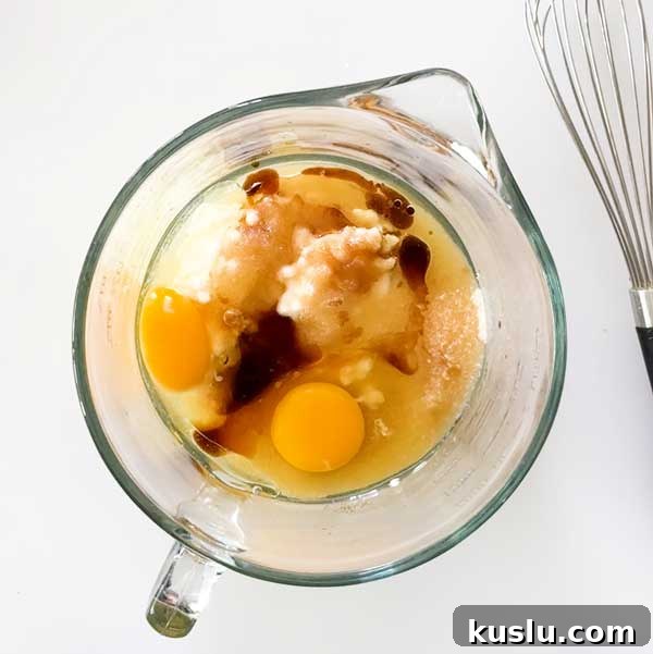 All the wet ingredients added to a mixing bowl for the muffin batter.