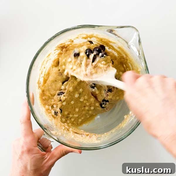 Holding the blueberries into the muffin batter.