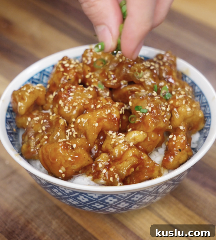 Crispy Korean Fried Chicken Recipe: How to Make Dakgangjeong 10 A final sprinkle of sliced scallions is added by hand to finish the Korean fried chicken rice bowl before serving.
