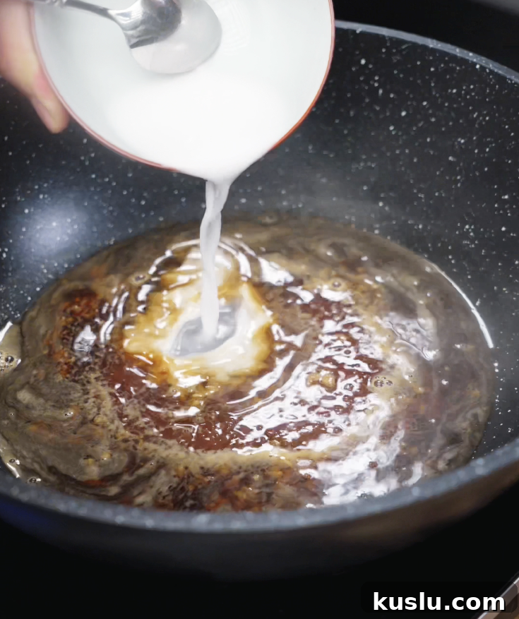Crispy Korean Fried Chicken Recipe: How to Make Dakgangjeong 8 A cornstarch slurry is poured into a simmering pan of soy sauce, honey, garlic, and water to thicken the glaze.