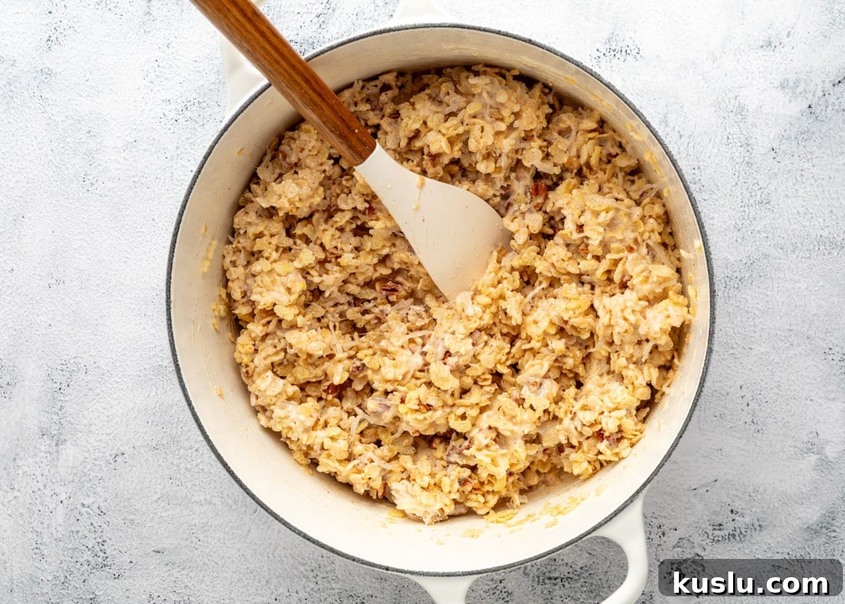 Coconut Pecan Rice Krispie Treats Recipe for Crispy Sweets 10 Mixed coconut pecan rice krispies treats in a white enameled cast iron pot with a wood handled spatula