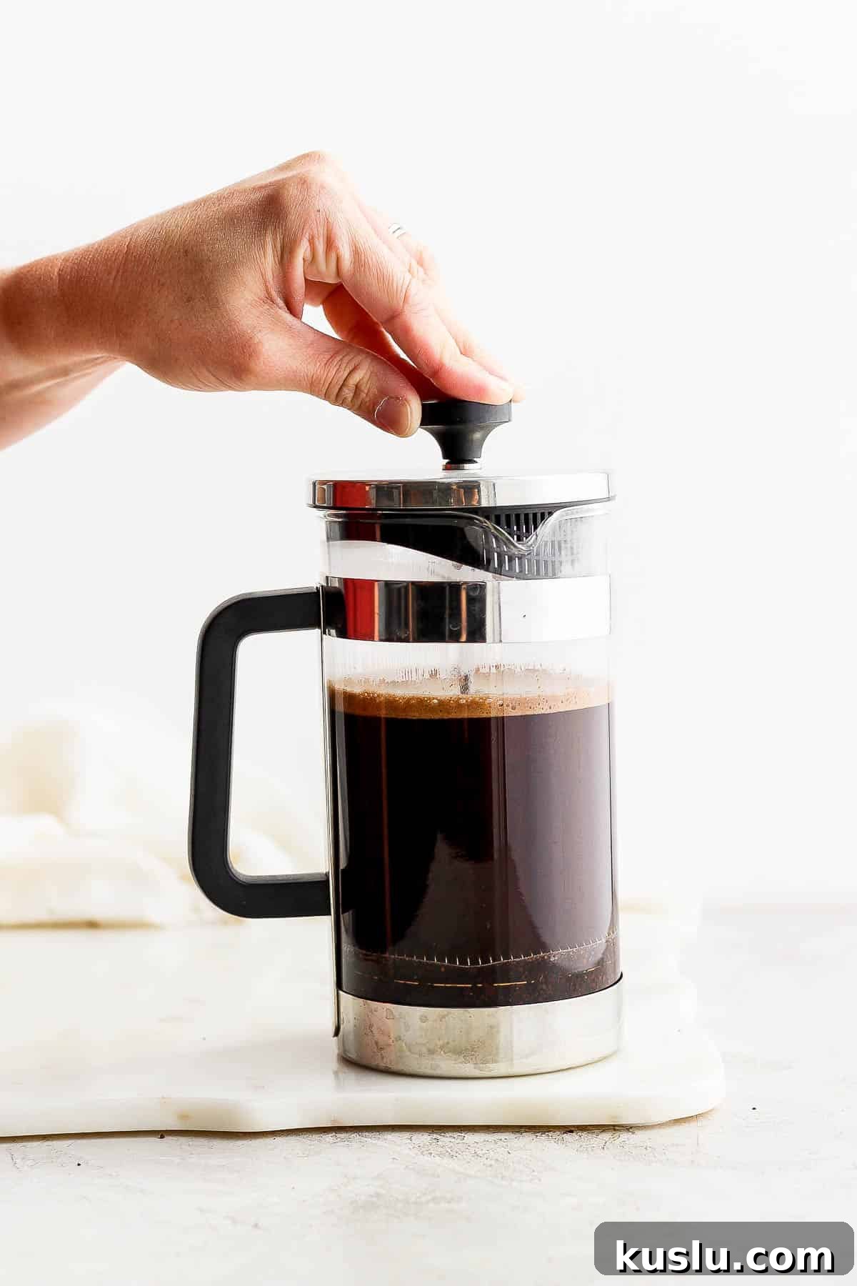 Someone pressing down on a french press.