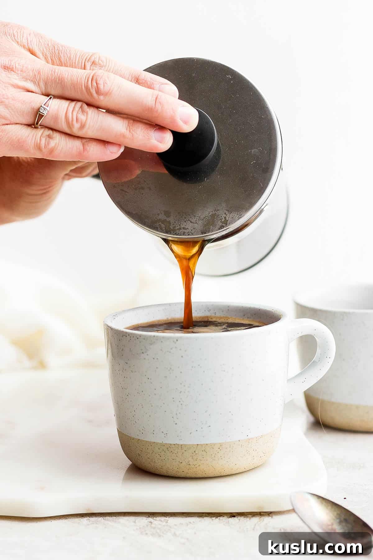 Someone pouring coffee out of a french press into a mug.