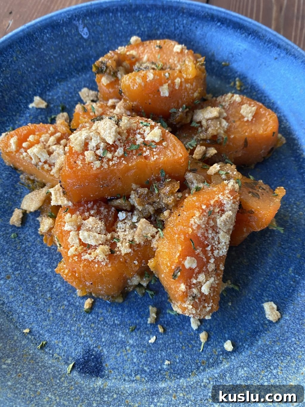 Baked sweet potato slices with crispy topping on a blue plate.