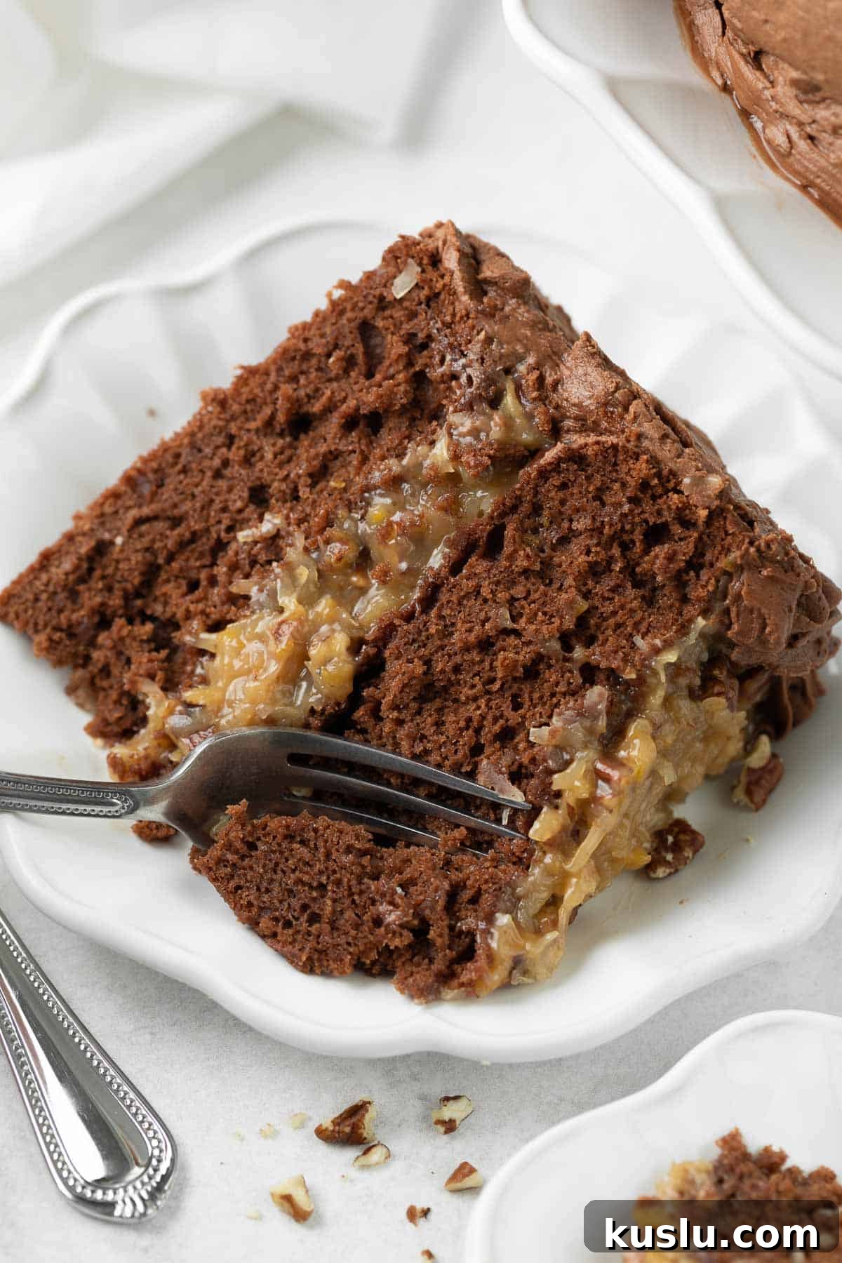 Gluten-Free German Chocolate Cake Recipe — Decadent & Moist 9 A slice of German chocolate cake on a plate, with a fork taking a bite