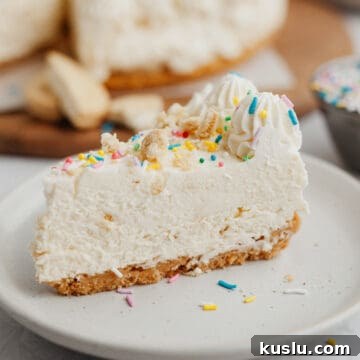 A slice of no bake cheesecake covered in rainbow sprinkles on a small beige plate