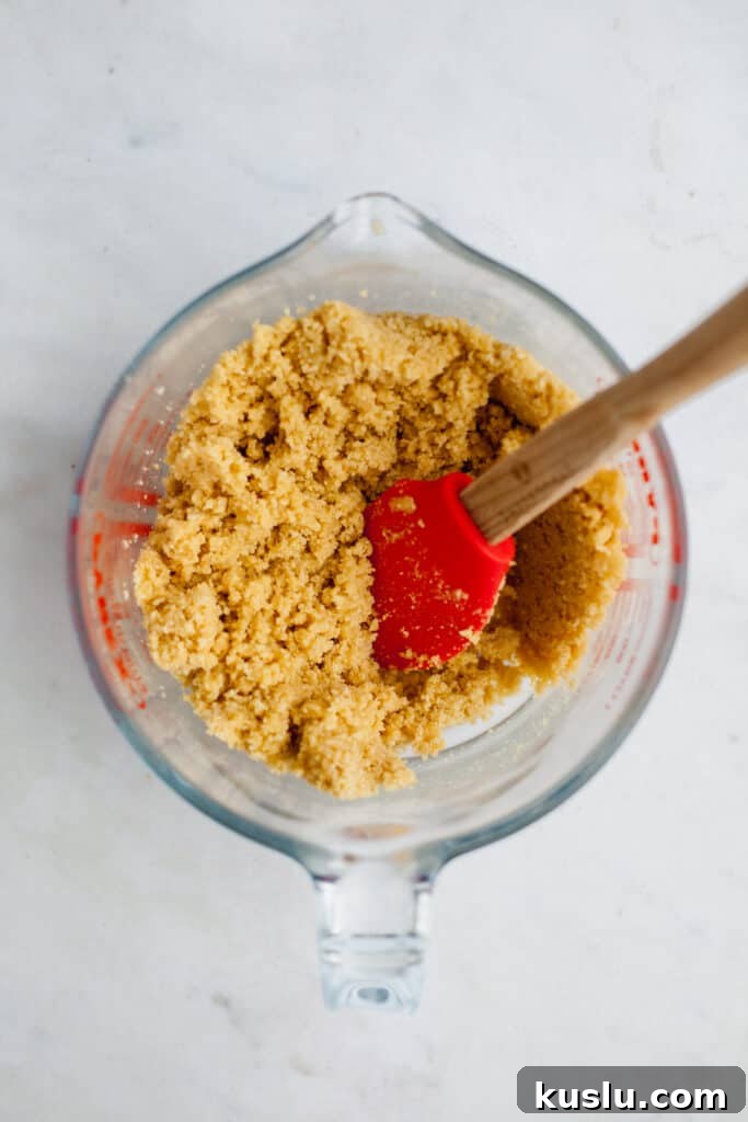 A pyrex mixing jug with golden oreo crumbs and melted butter mixed together
