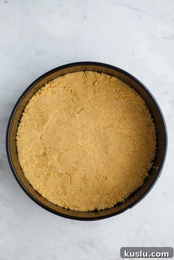 A springform pan with an unbaked golden oreo cheeescake crust