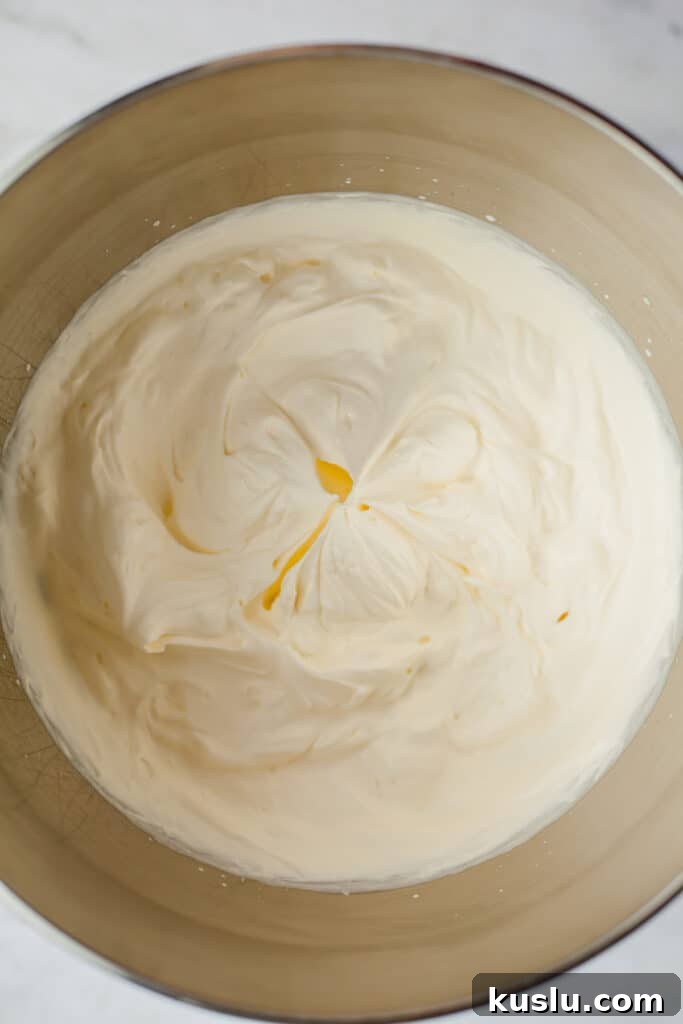 Whipped cream in a large silver mixing bowl