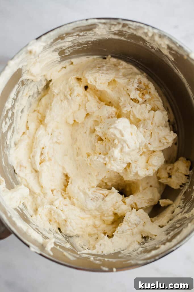 A silver bowl with cheesecake batter in it