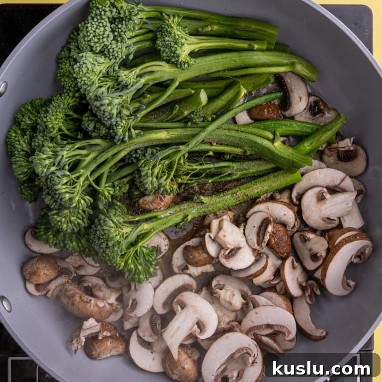 15-Minute Sautéed Broccolini with Garlic Mushrooms 14 Adding mushrooms and broccolini to a pan with hot oil