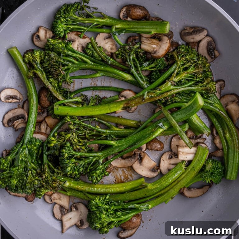 15-Minute Sautéed Broccolini with Garlic Mushrooms 15 Browned broccolini sitting atop mushrooms in a pan