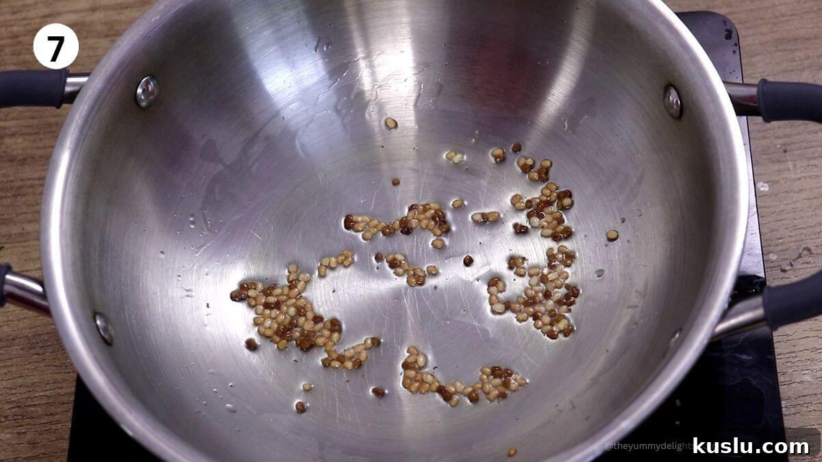 tempering of urad and methi in a pan for bangdyachi uddamethi recipe.