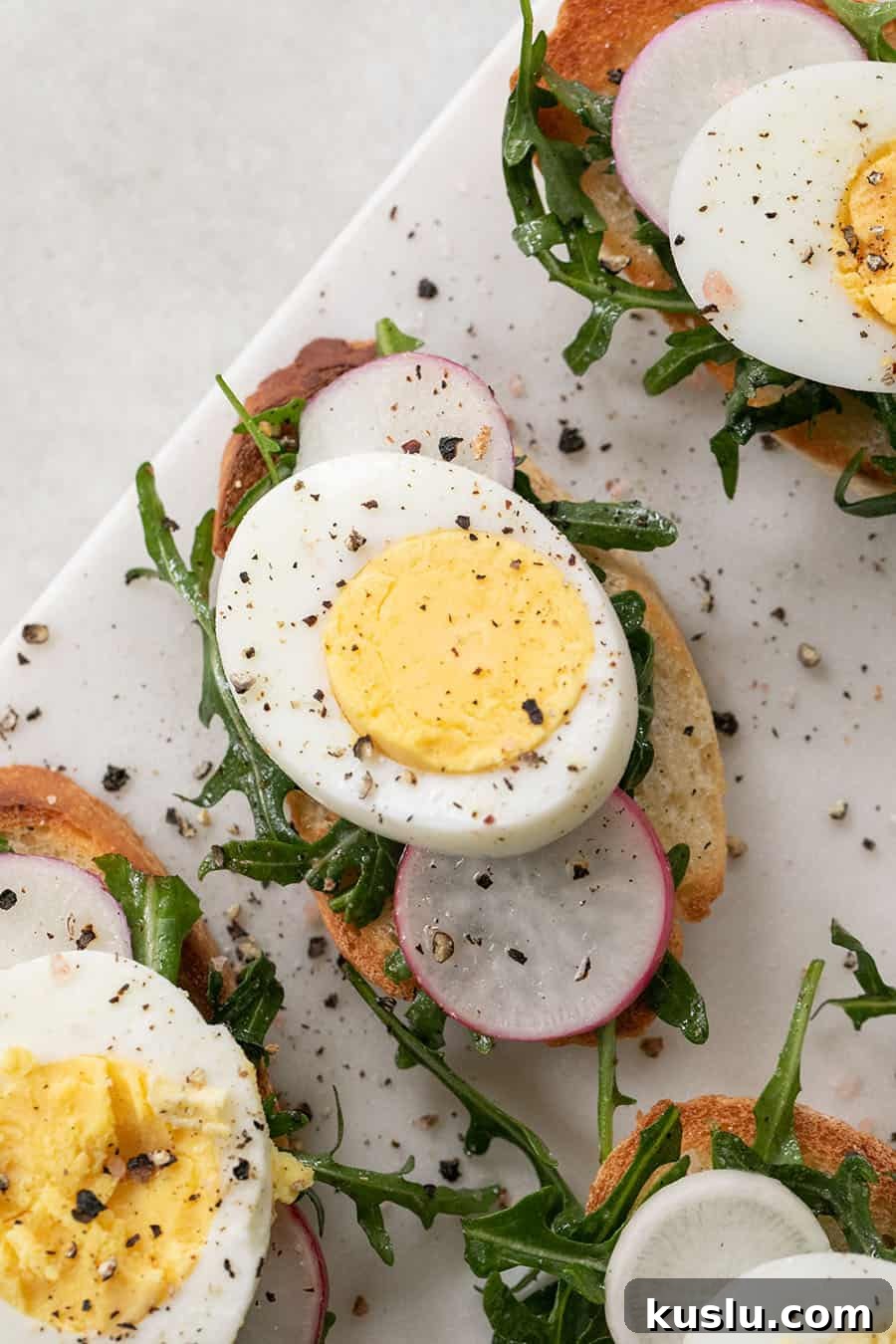 hard boiled egg, sliced on a crostini with salt and pepper and radish