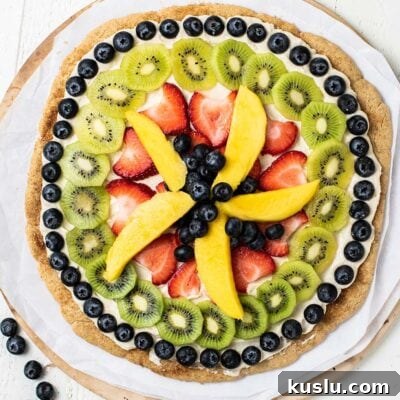 Fresh Fruit Pizza on a Crisp Cookie Crust: Summer Dessert Recipe 10 A whole fruit pizza shown on a pizza stone.