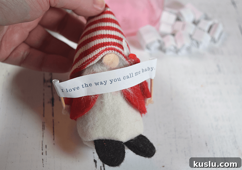 The little gnome holding up the love note banner.