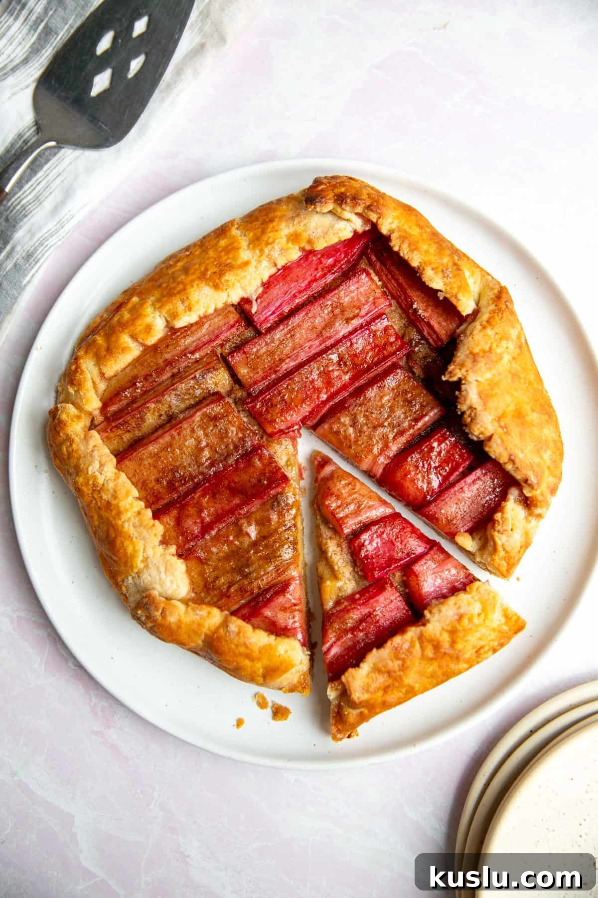 a rhubarb galette on a white plate with one slice resting on the side