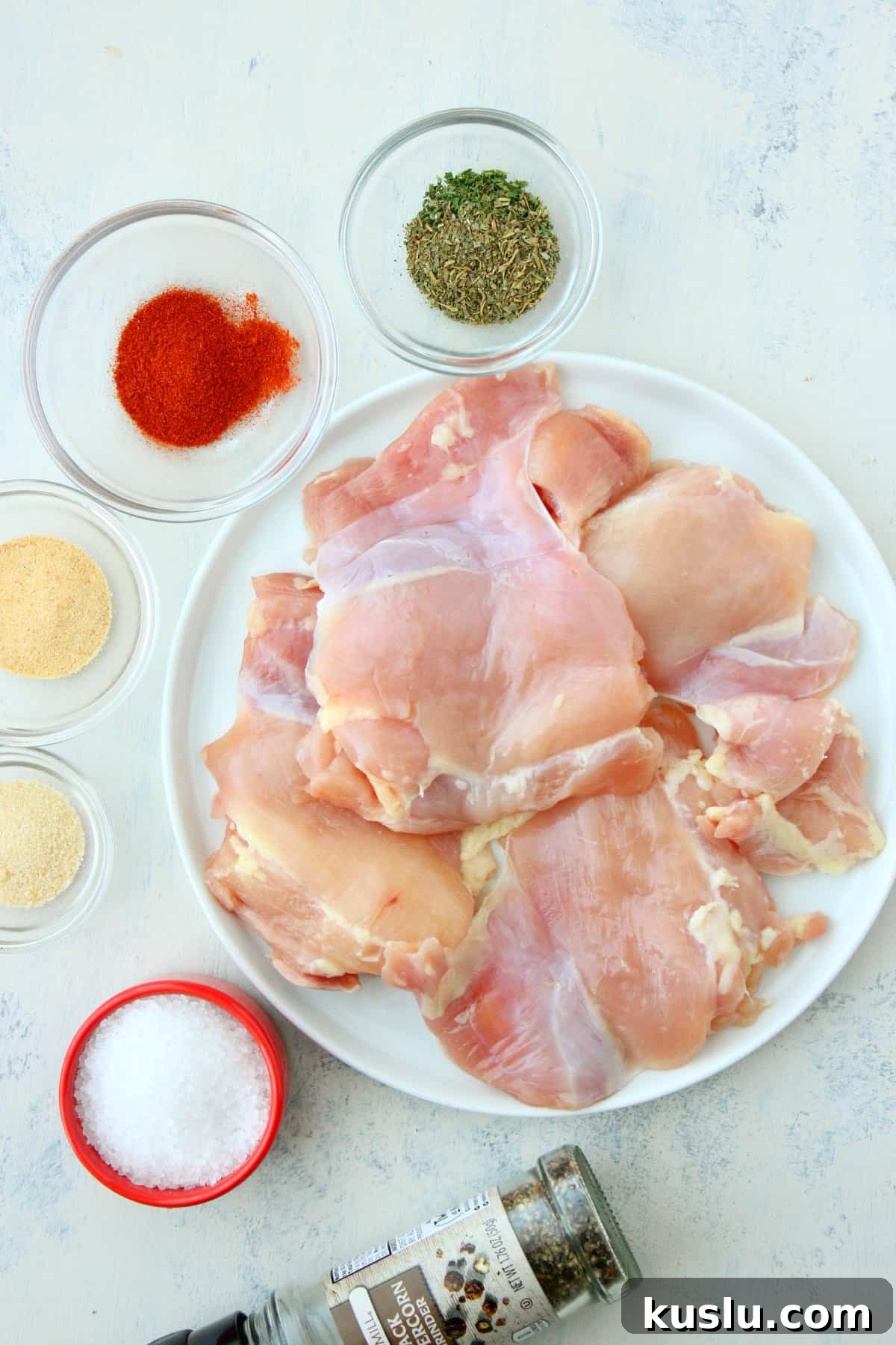 Skillet chicken thighs ingredients Chicken thighs and spices on a white board.