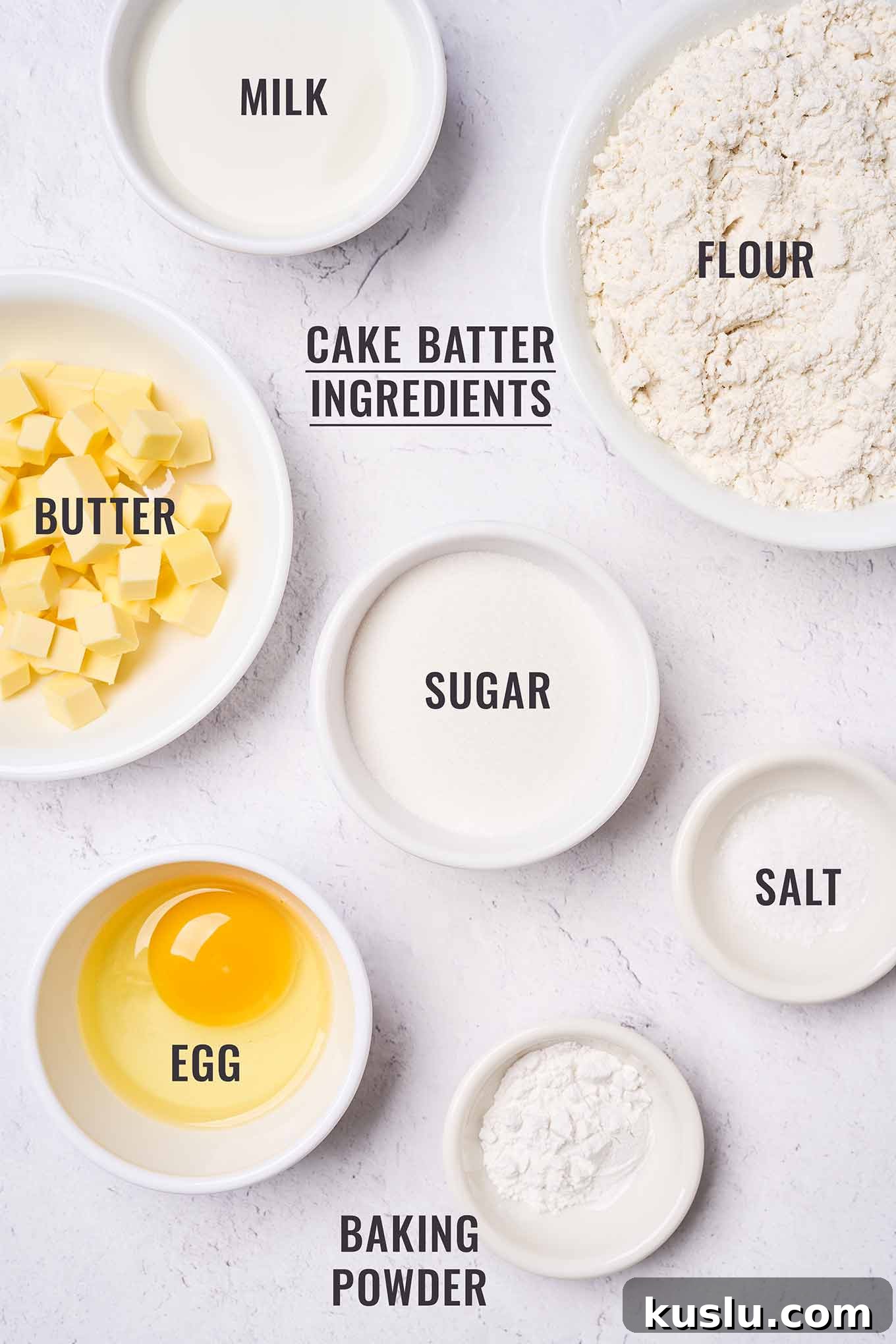 Moist Golden Delicious Apple Cake Recipe for Fall Baking 3 Labeled, overhead view of the ingredients for Golden Delicious apple cake batter in prep bowls; including flour, butter, sugar, egg, milk,baking powder, and salt.