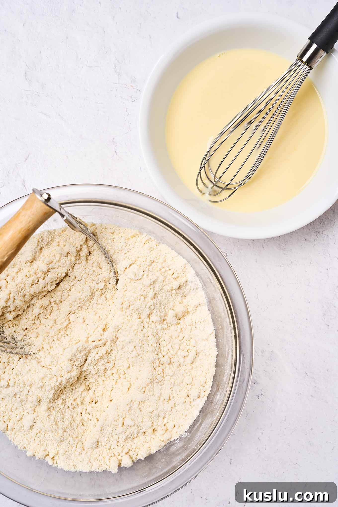 Moist Golden Delicious Apple Cake Recipe for Fall Baking 5 Making Golden Delicious apple cake; two mixing bowls, one with dry ingredients showing consistency, another bowl with wet ingredients and a whisk.