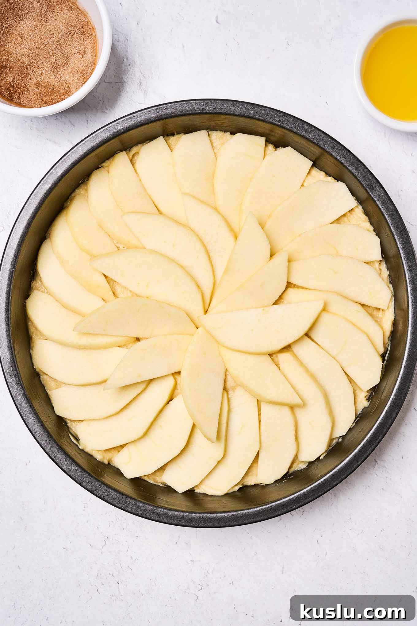 Moist Golden Delicious Apple Cake Recipe for Fall Baking 6 Golden Delicious apple cake batter in the pan and topped with apple slices, waiting to be topped with melted butter and cinnamon sugar.