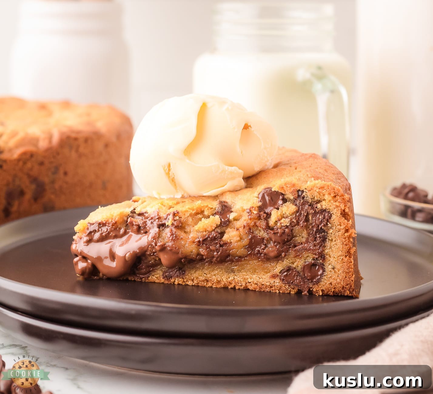 Nutella cookie cake topped with ice cream on a black plate
