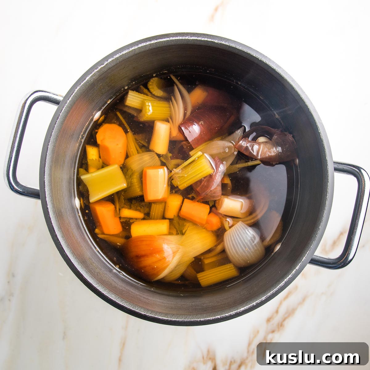 How to Make Flavorful Homemade Vegetable Broth from Scratch 5 Cooked vegetables in a large pot filled with water that is now broth.