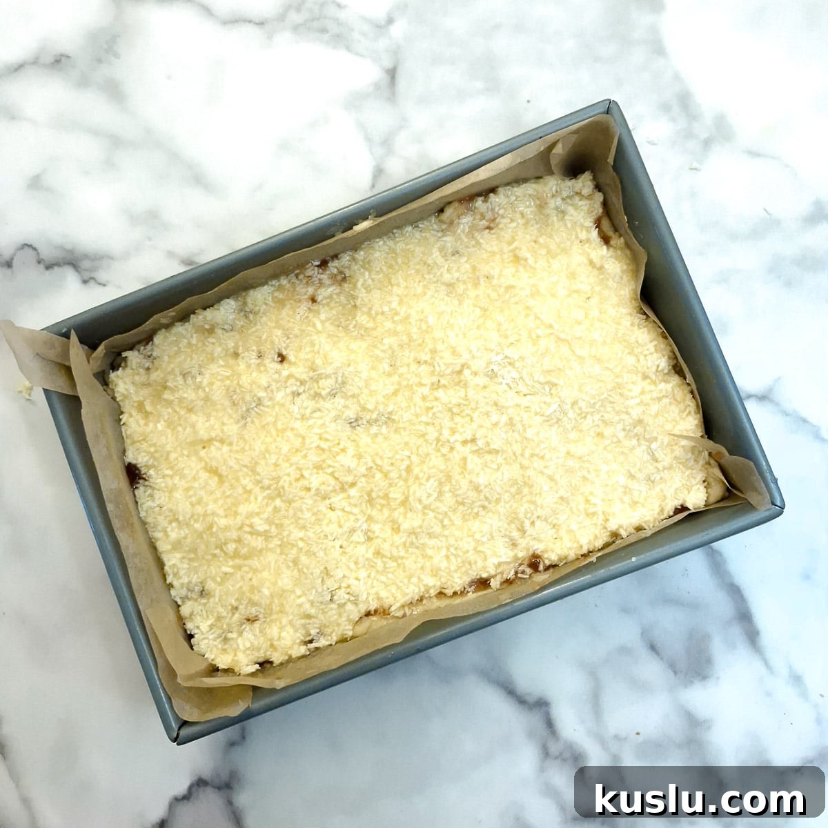 Coconut topping spread on top of the layer of jam.