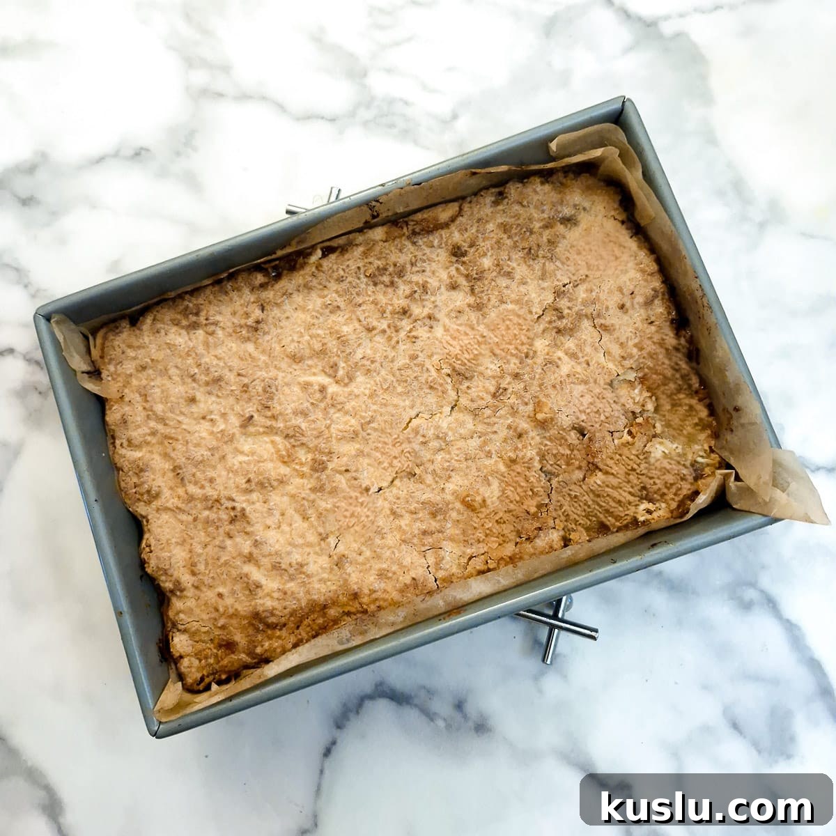 A baked coconut jam slice in a baking dish.