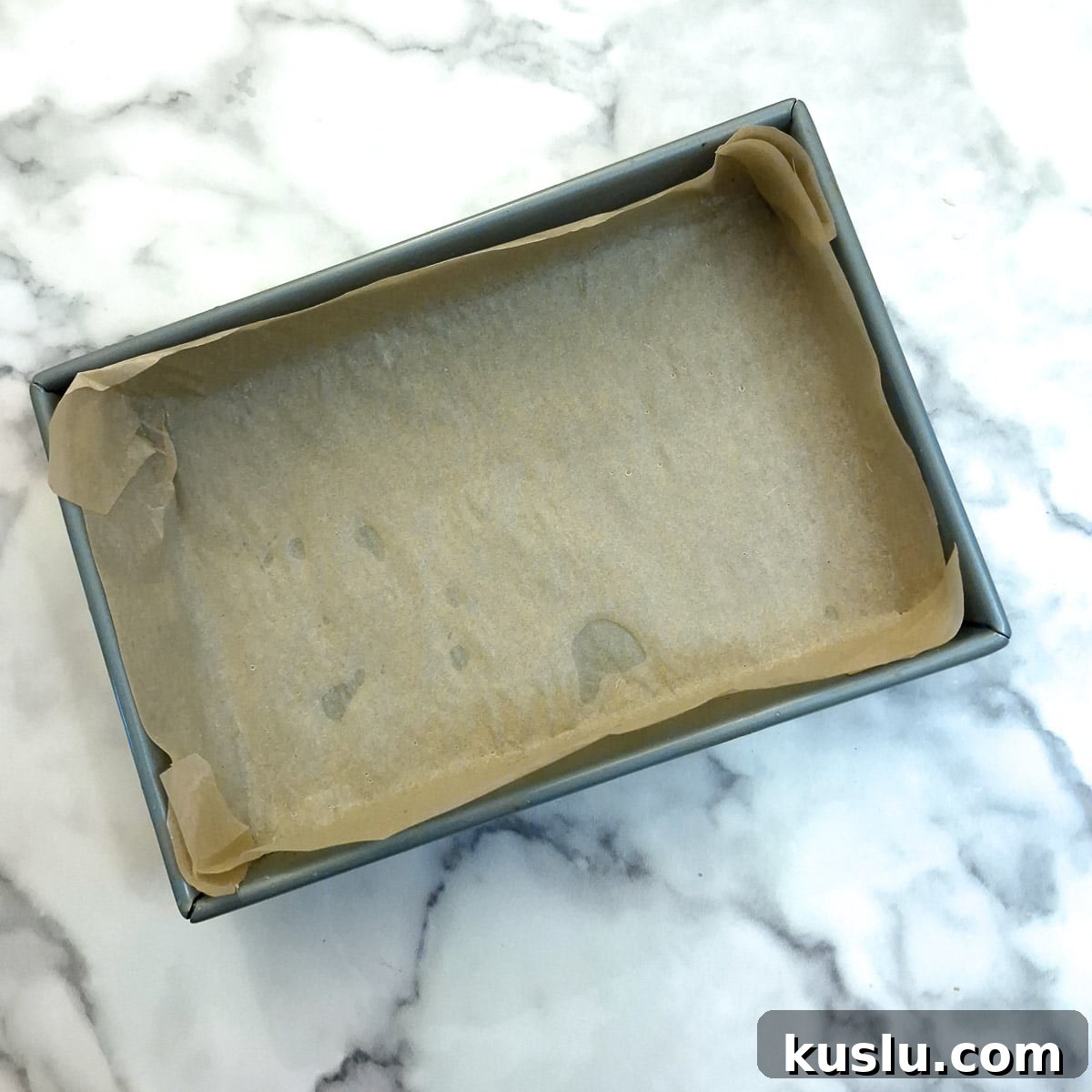 A baking pan lined with baking parchment.